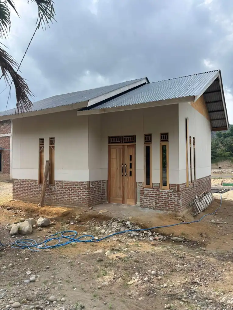 Hunian satu lantai dengan atap miring dan teras memanjang di bagian depan.